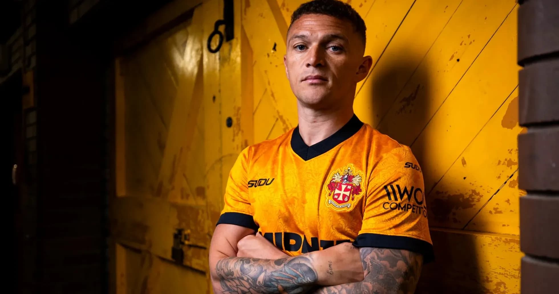 Jugador posando con camiseta de equipo frente a fondo amarillo