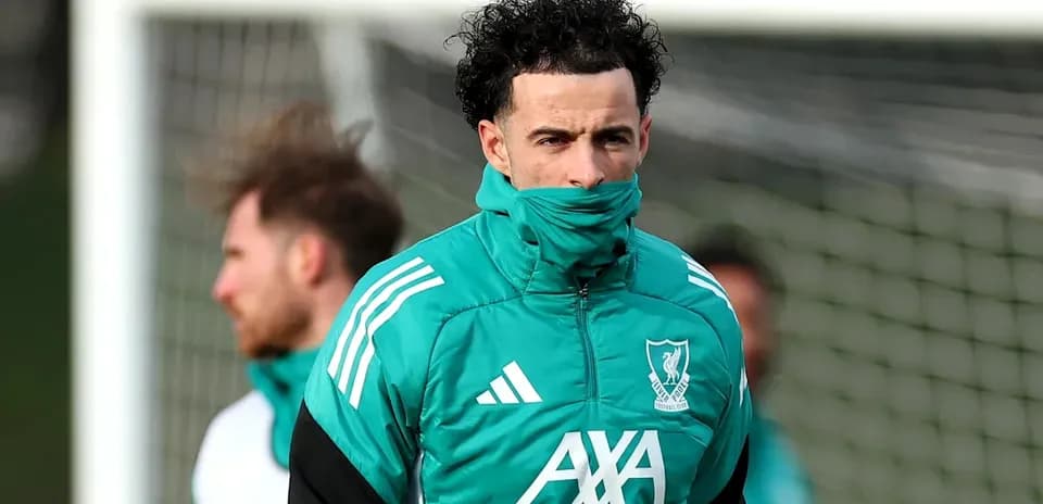 Jugador entrenando con abrigo de Liverpool FC