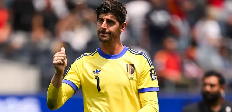 Portero belga con camiseta amarilla gesticulando en el campo