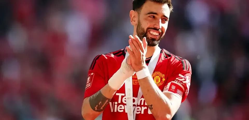 Bruno Fernandes aplaudiendo con medalla de campeón