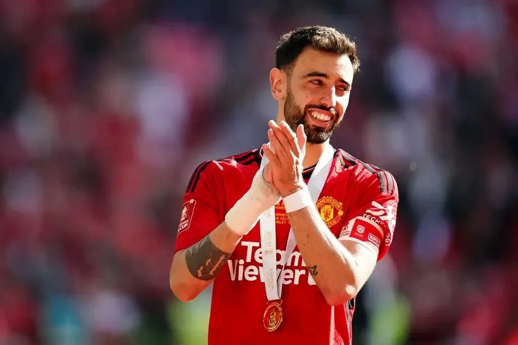 Bruno Fernandes aplaudiendo con medalla de campeón