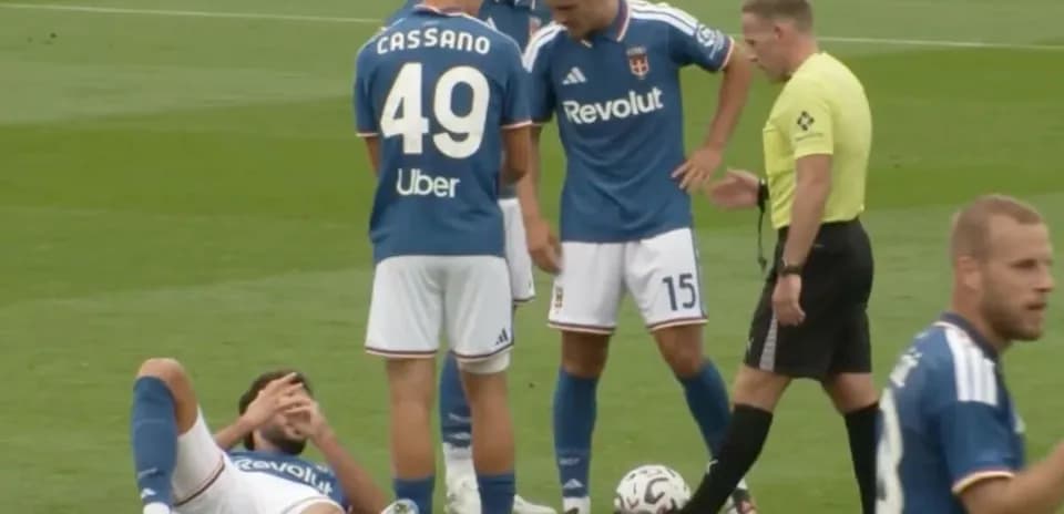 Jugador caído en el campo, árbitro y compañeros presentes