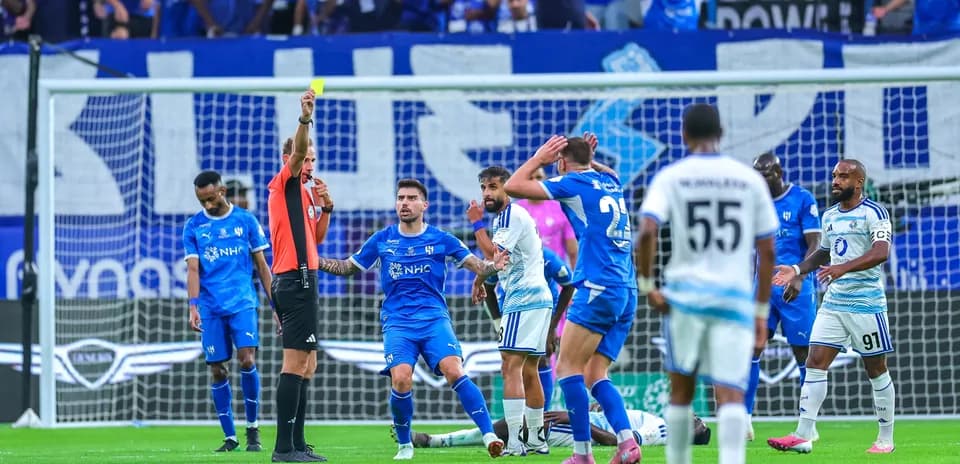 Árbitro muestra tarjeta amarilla en el partido