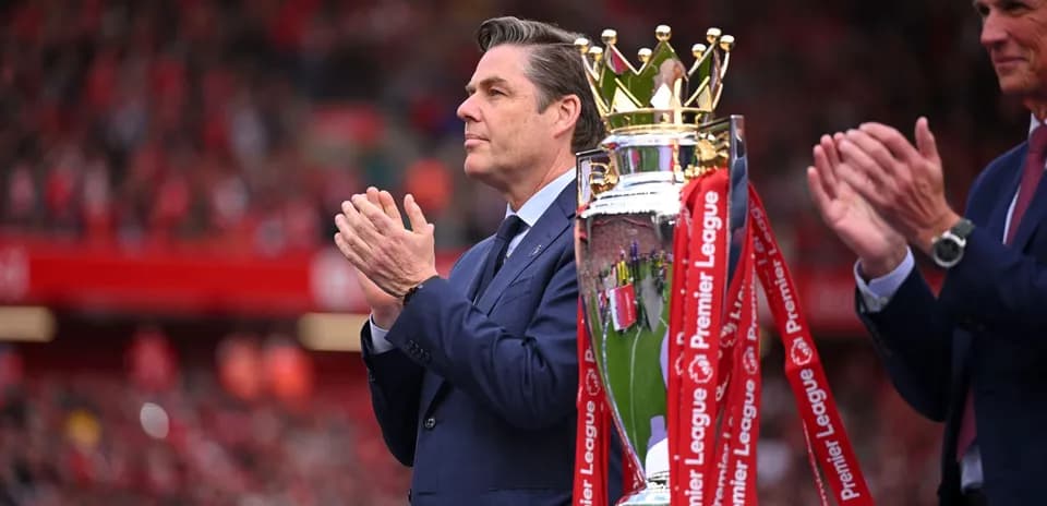 Hombre aplaudiendo junto a trofeo de Premier League