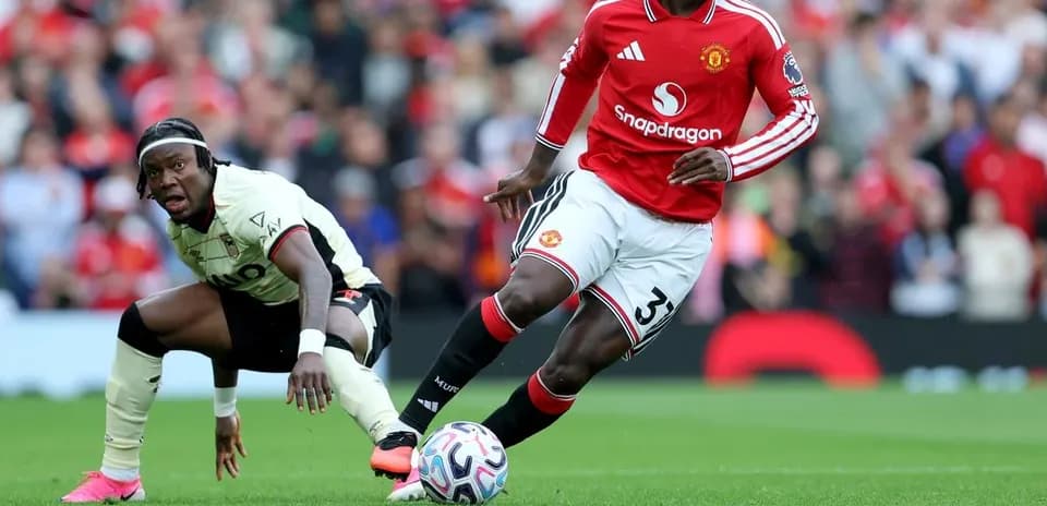 Jugador de Manchester United driblando a oponente en el campo