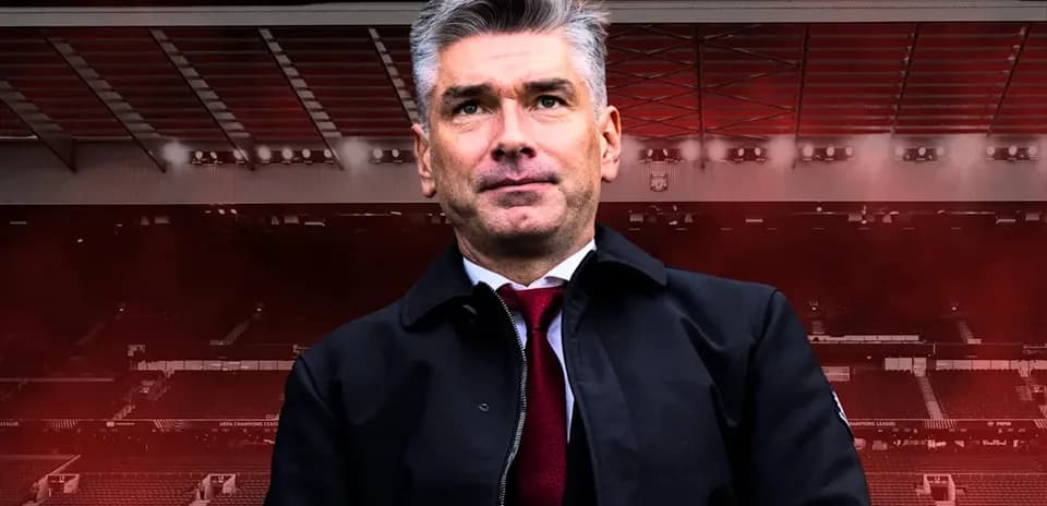 Entrenador posando en estadio con fondo oscuro