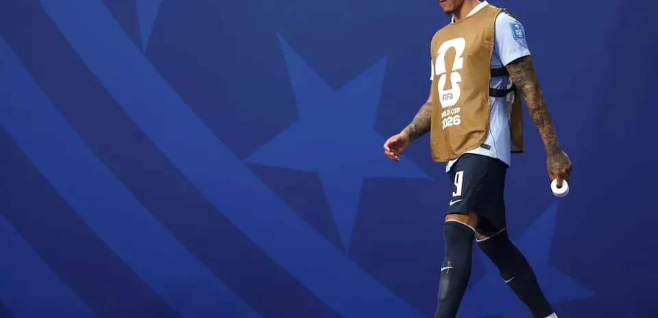 Jugador saliendo al campo con pechera de entrenamiento