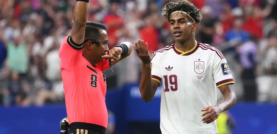 Árbitro mostrando tarjeta a jugador durante partido