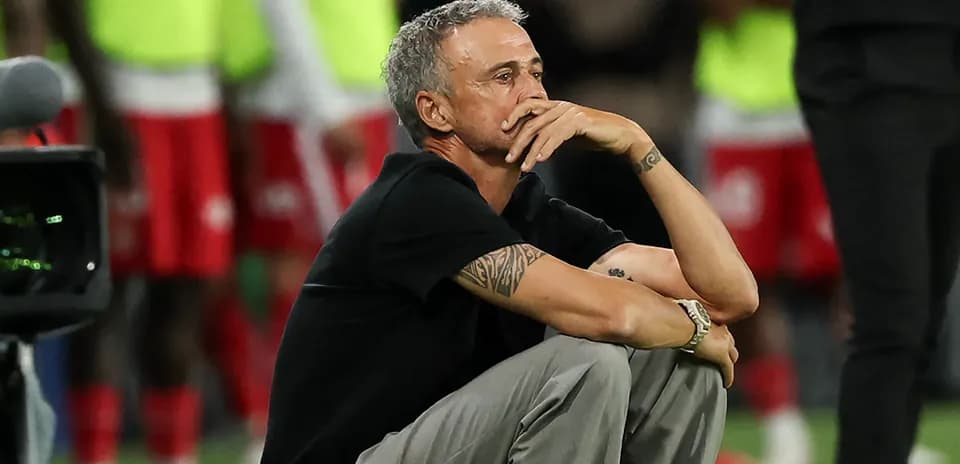 Entrenador sentado en la línea de banda durante el partido