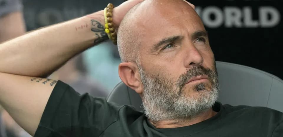 Entrenador sentado en banco durante partido