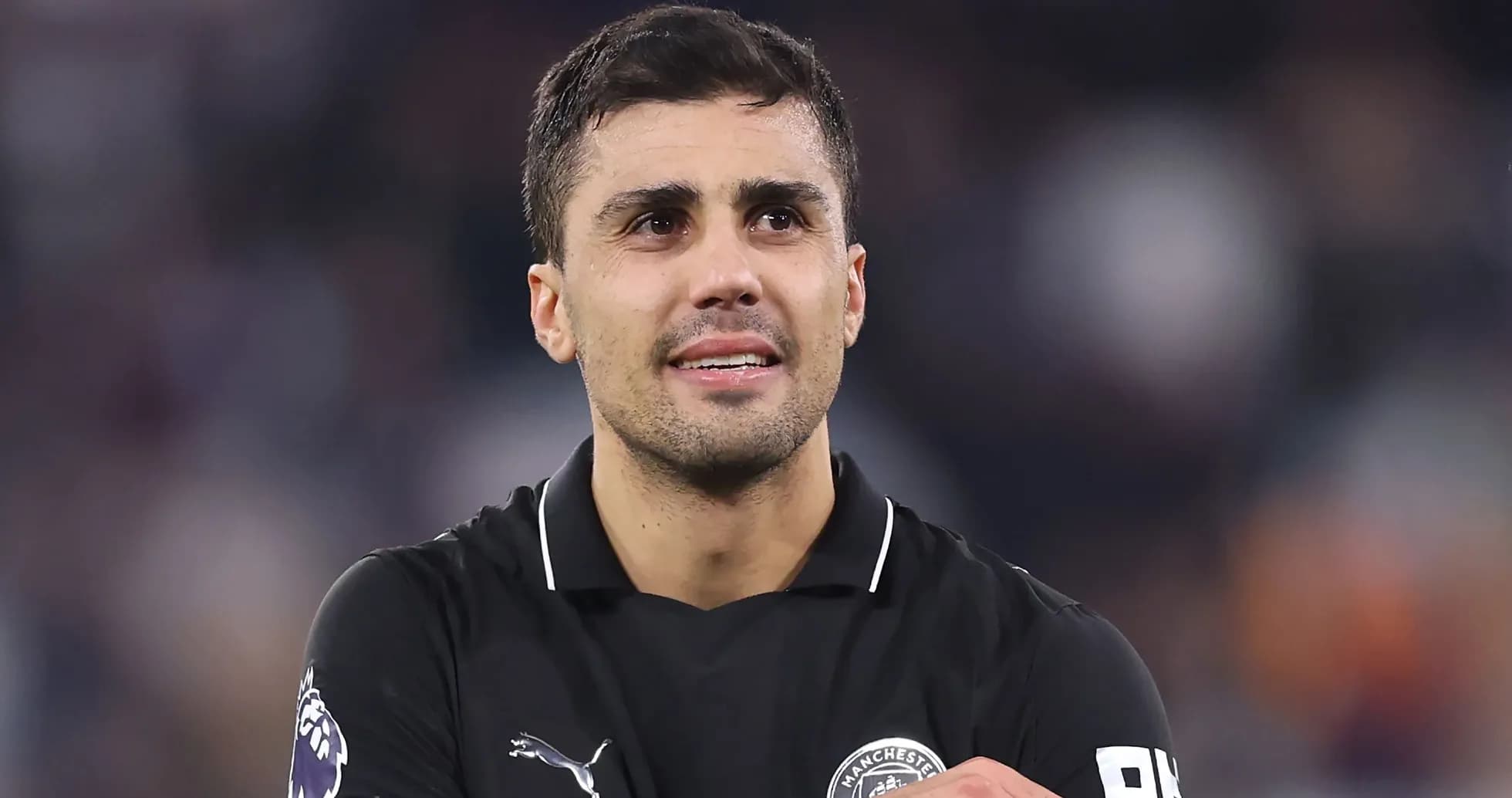 Jugador de fútbol en uniforme negro sonriendo