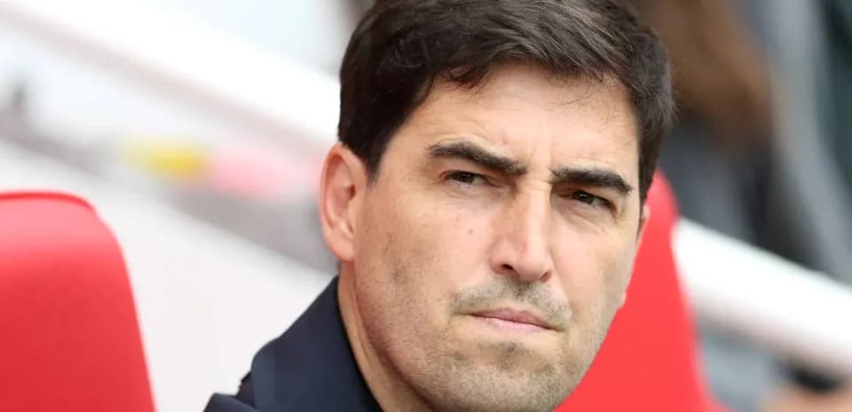 Entrenador observando el partido desde el banquillo