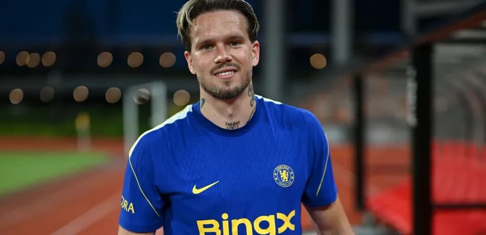 Jugador sonriente con camiseta de Chelsea en campo