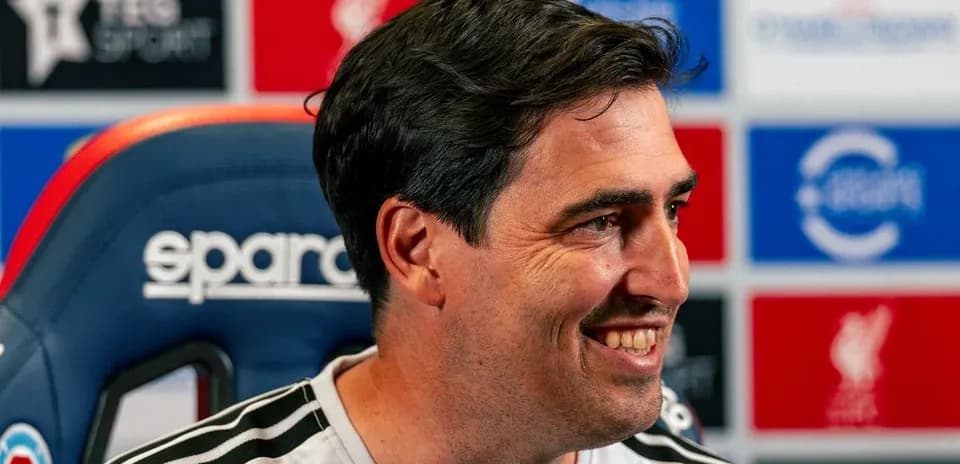 Entrenador sonriente en conferencia de prensa