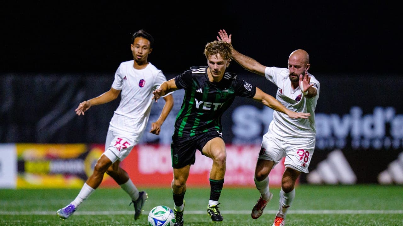 Jugador de Austin II esquivando a defensores de St. Louis City II
