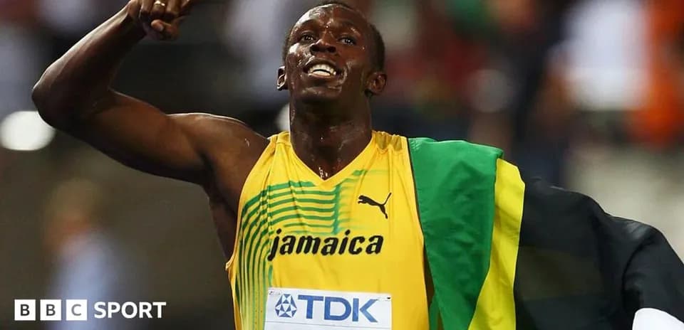 Atleta celebrando en pista con bandera de Jamaica