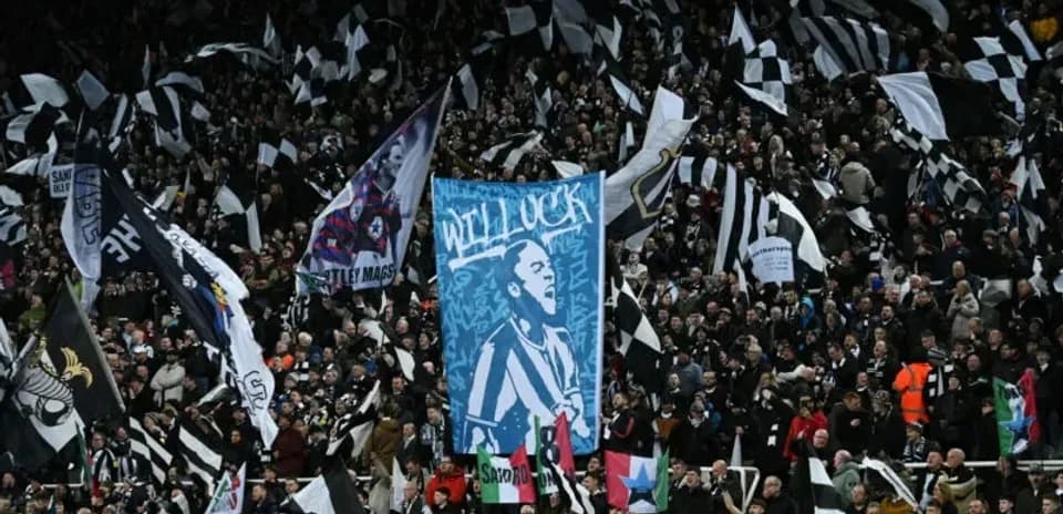 Aficionados con banderas en el estadio durante un partido