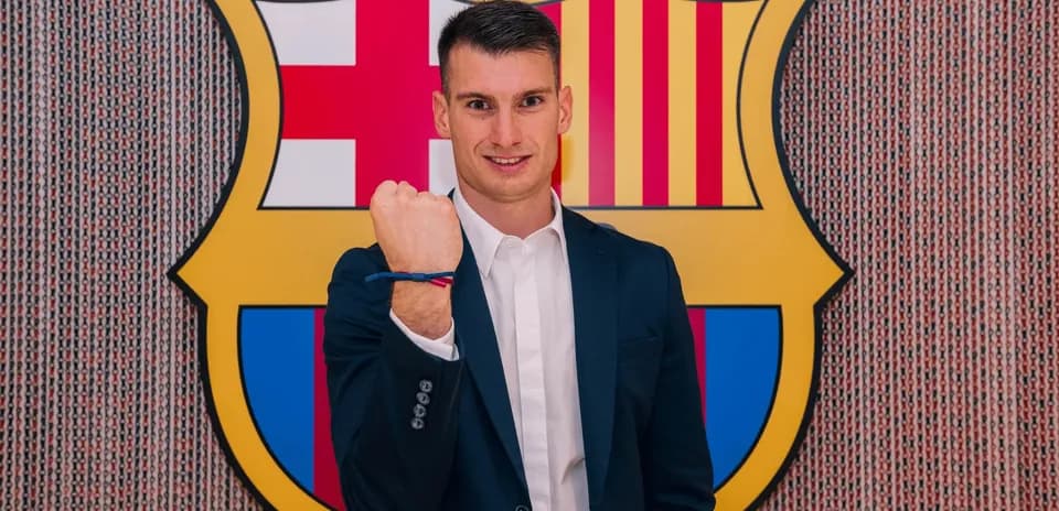 Jugador mostrando su puño frente al escudo del Barcelona