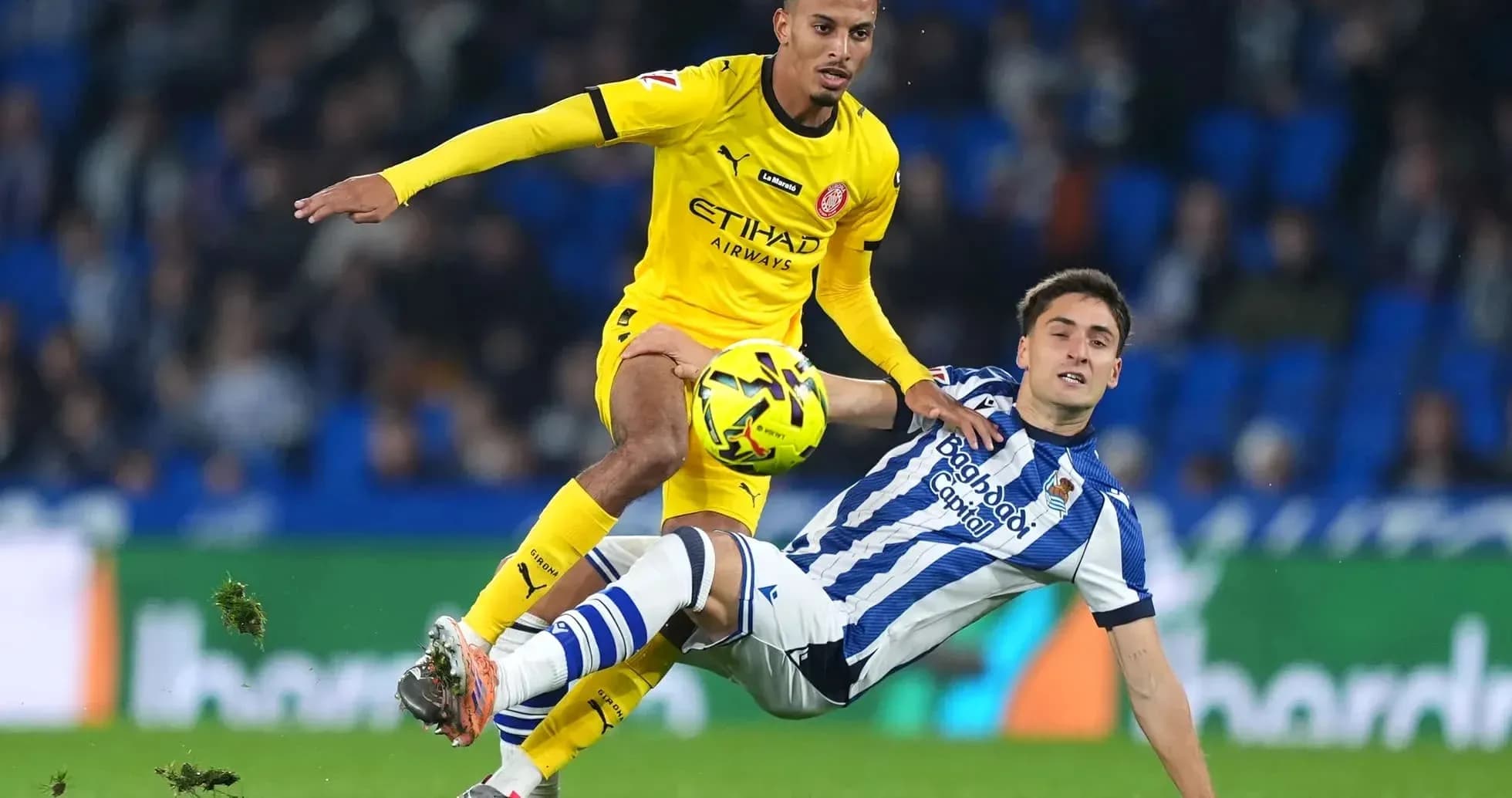 Jugador de Girona superando a rival de la Real Sociedad
