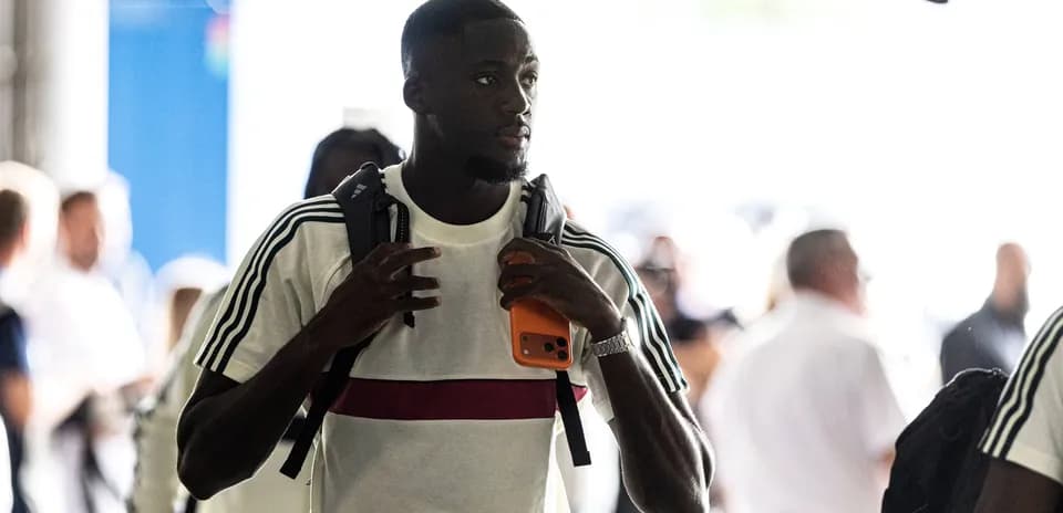 Jugador llegando con mochila y teléfono en mano