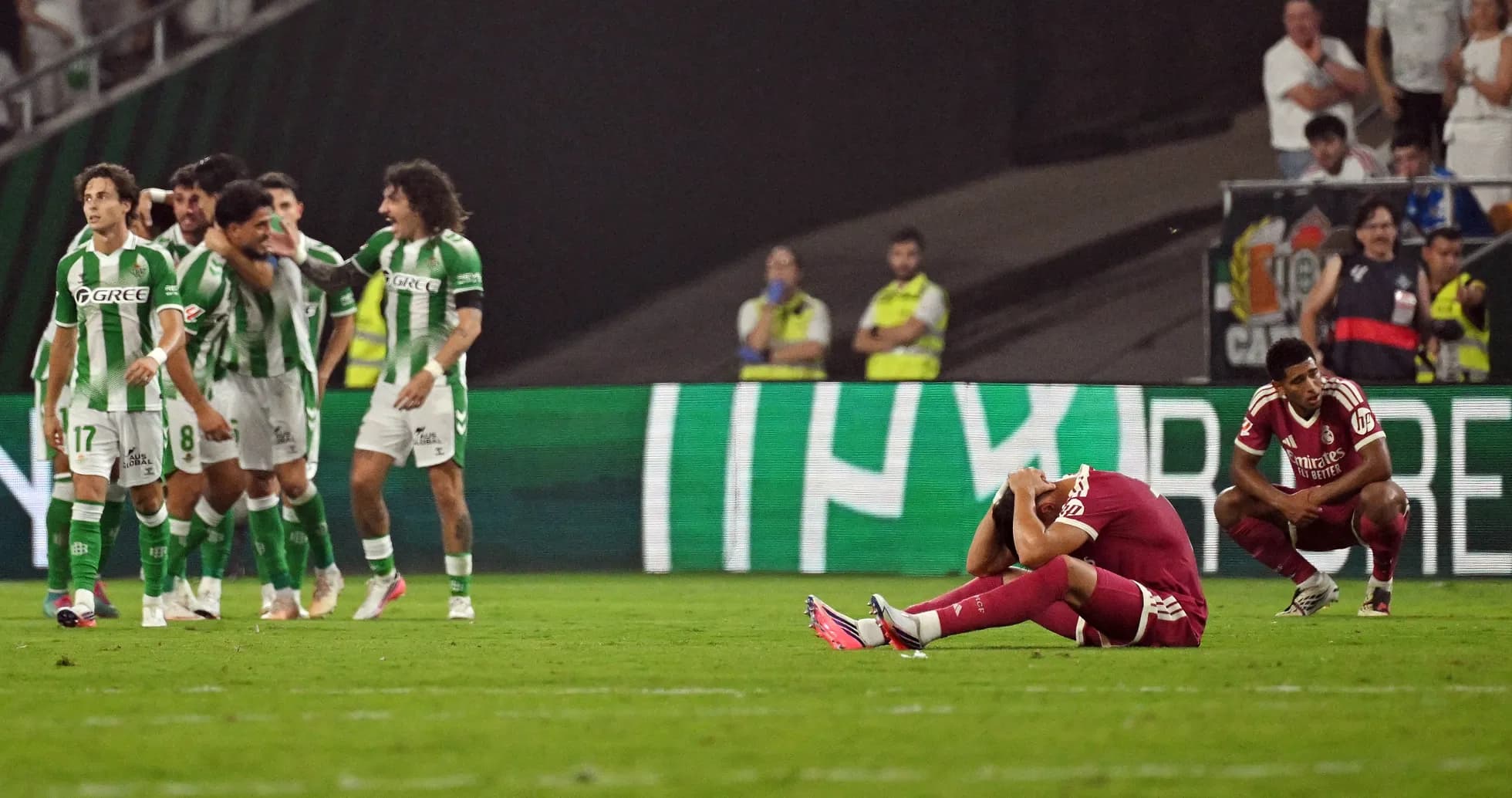 Jugadores de Betis celebrando gol, oponente desanimado Jugadores de Betis celebrando gol, oponente desanimado