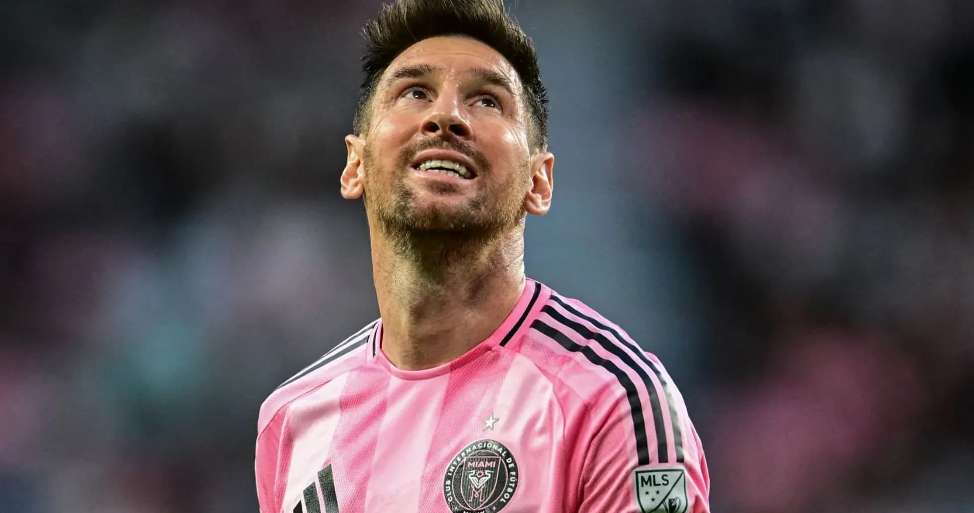 Jugador de fútbol con camiseta rosa mirando hacia arriba Jugador de fútbol con camiseta rosa mirando hacia arriba