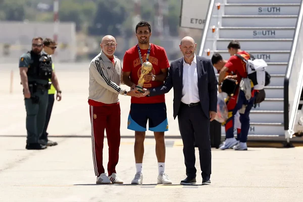 Jugador sosteniendo trofeo con directivos en aeropuerto Jugador sosteniendo trofeo con directivos en aeropuerto