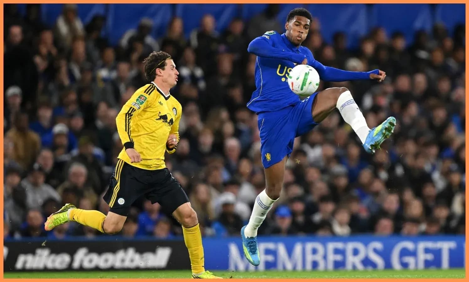 Jugador de equipo azul controla el balón en el aire Jugador de equipo azul controla el balón en el aire