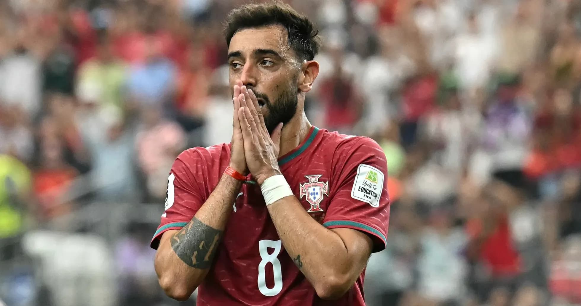 Jugador de Portugal con camiseta roja, manos en la cara Jugador de Portugal con camiseta roja, manos en la cara