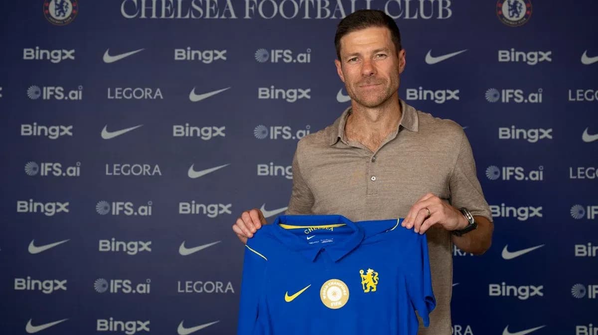 Entrenador sosteniendo camiseta de Chelsea FC en presentación Entrenador sosteniendo camiseta de Chelsea FC en presentación
