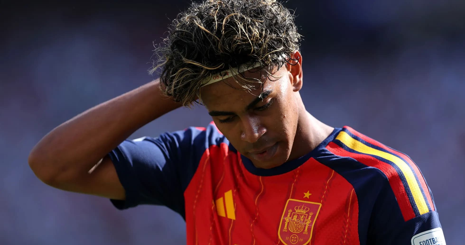 Jugador de España con camiseta roja mirando hacia abajo Jugador de España con camiseta roja mirando hacia abajo