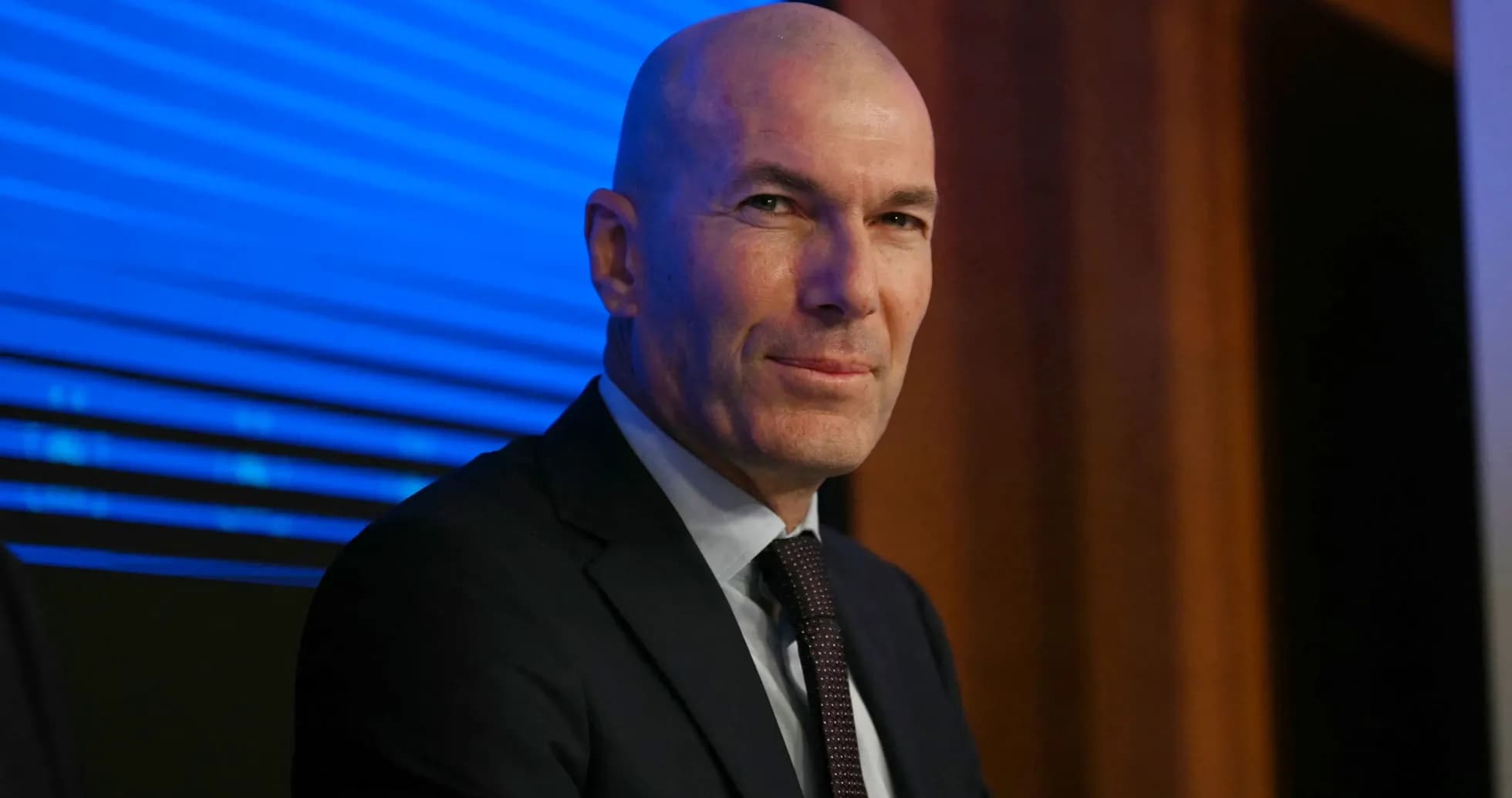Hombre sentado en conferencia de prensa con fondo azul Hombre sentado en conferencia de prensa con fondo azul