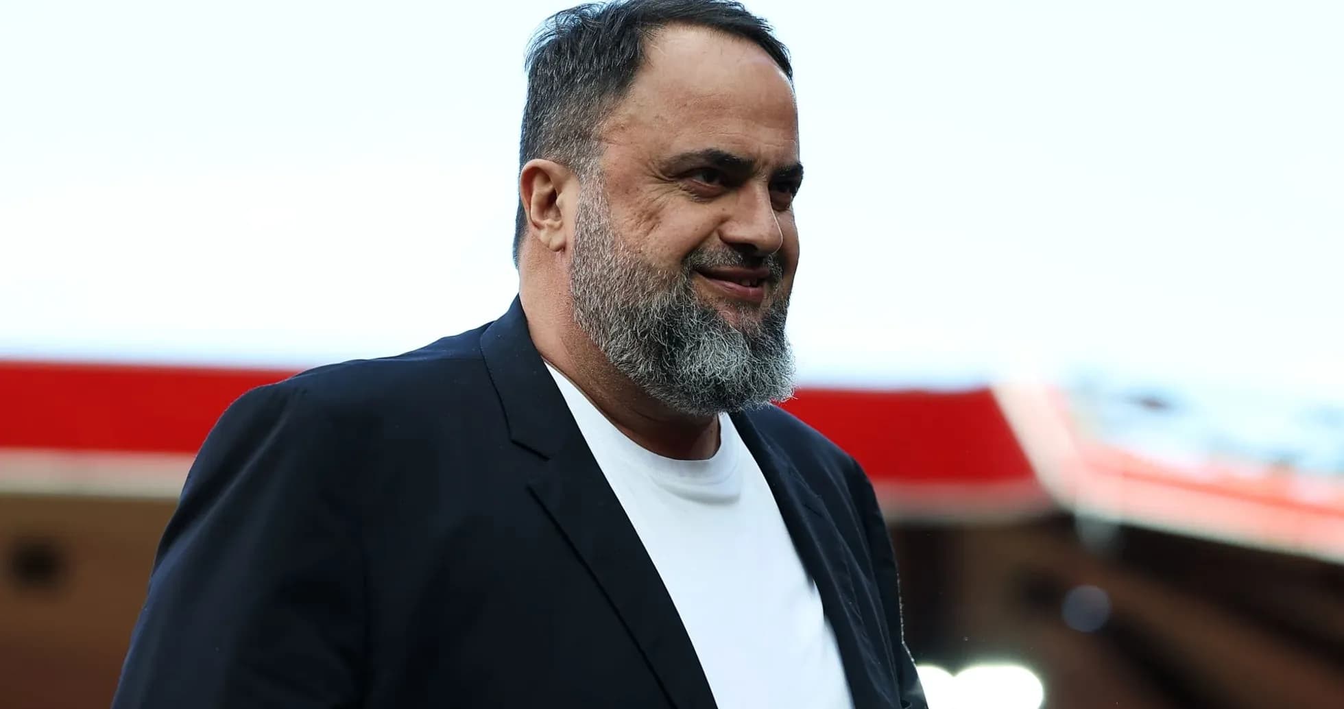 Hombre con barba sonriendo en un estadio Hombre con barba sonriendo en un estadio