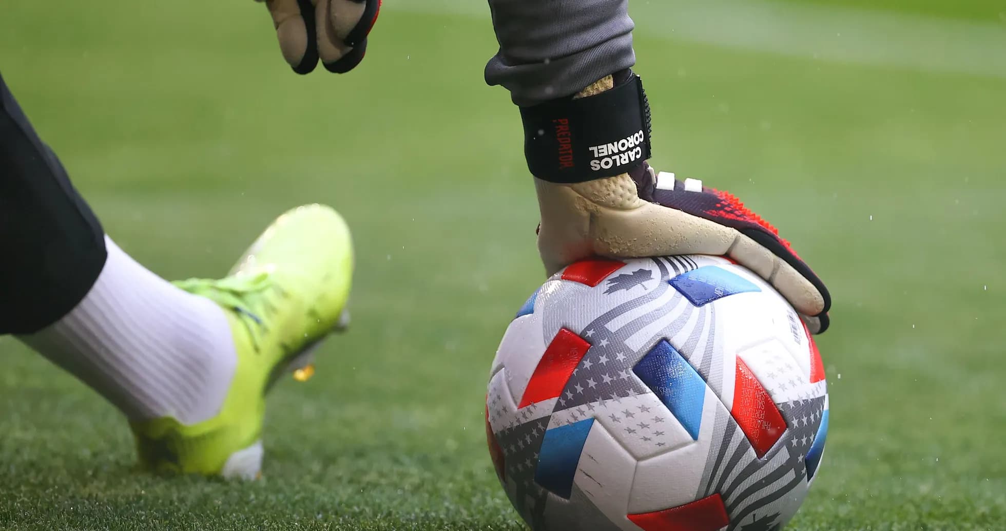 Portero sosteniendo un balón de fútbol en el césped Portero sosteniendo un balón de fútbol en el césped