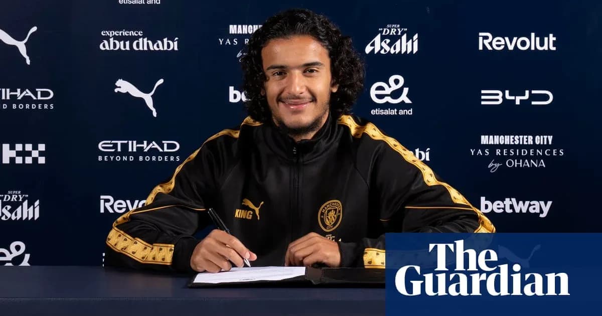 Jugador firmando contrato en mesa de prensa Jugador firmando contrato en mesa de prensa