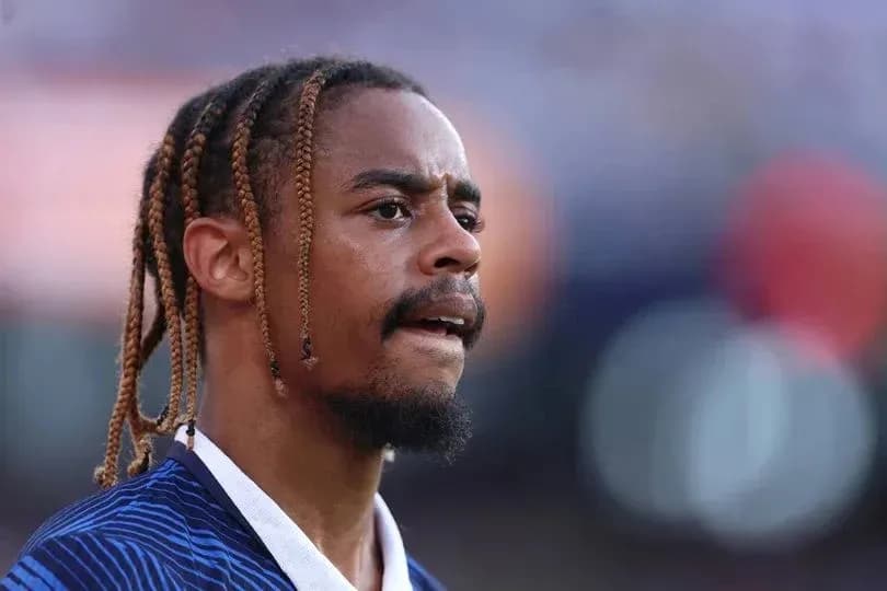 Jugador con trenzas durante un partido de fútbol Jugador con trenzas durante un partido de fútbol