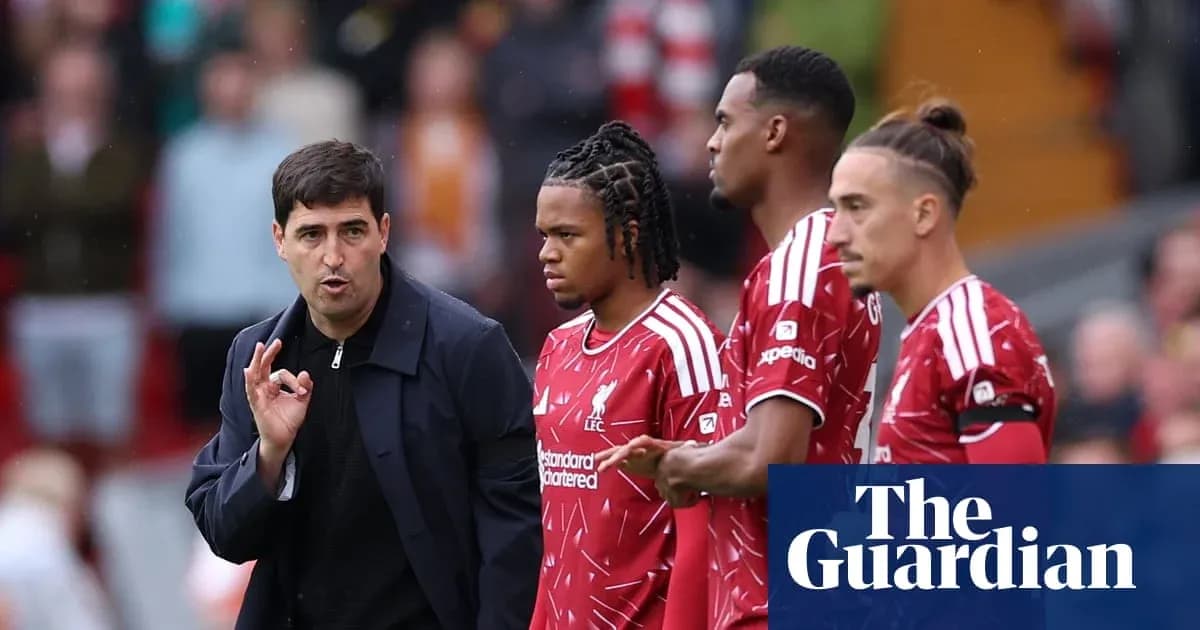 Entrenador dando instrucciones a jugadores de Liverpool Entrenador dando instrucciones a jugadores de Liverpool