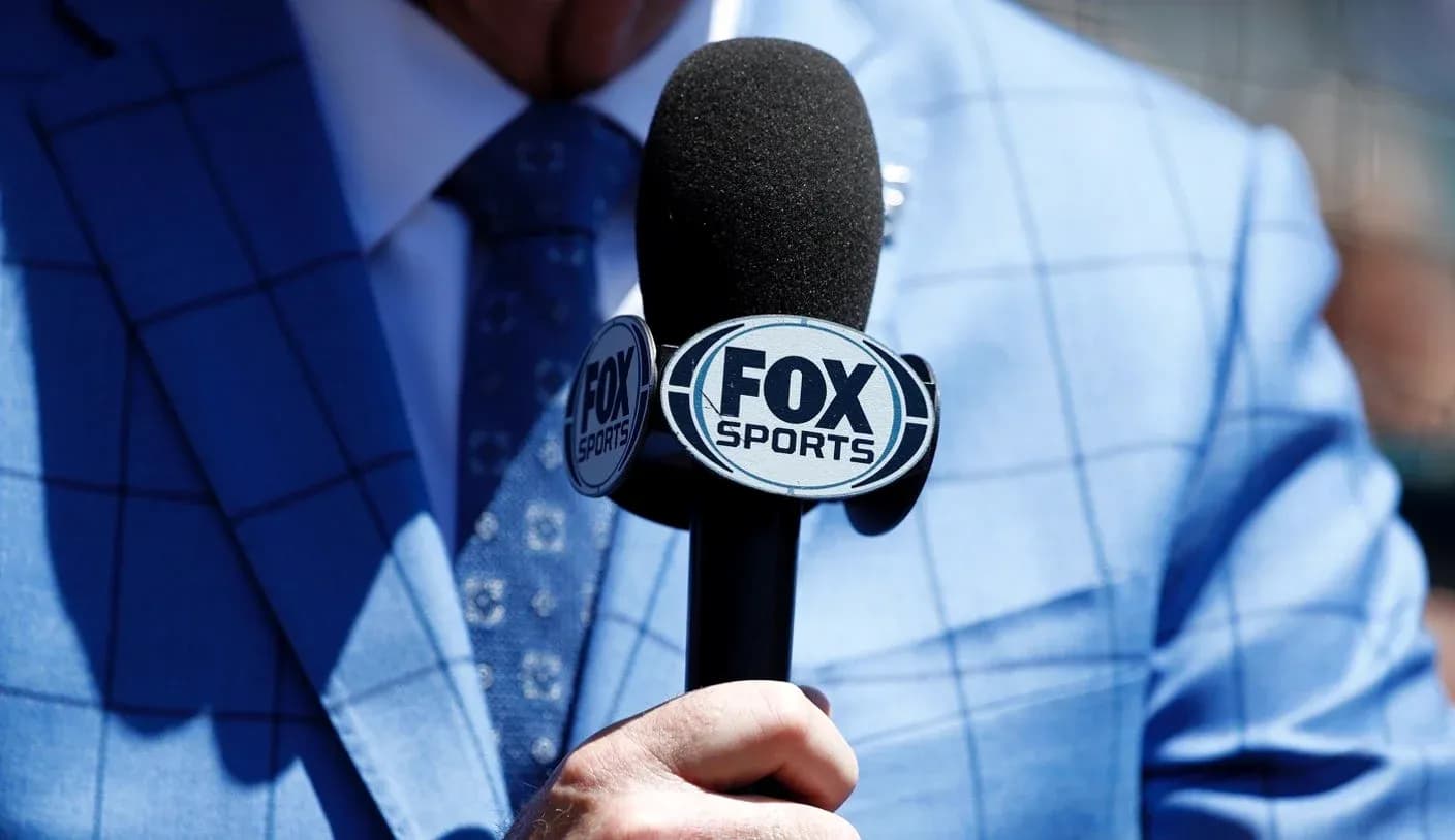 Micrófono de FOX Sports en mano con traje azul Micrófono de FOX Sports en mano con traje azul