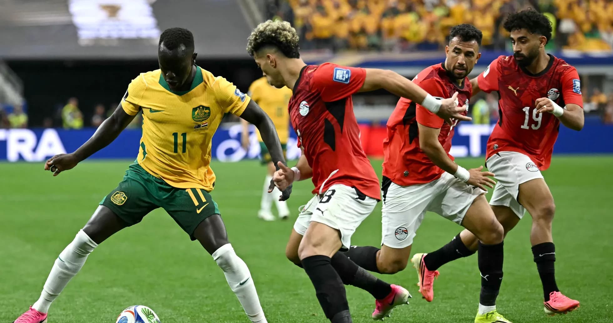 Jugador de Australia driblando a defensores egipcios en partido Jugador de Australia driblando a defensores egipcios en partido