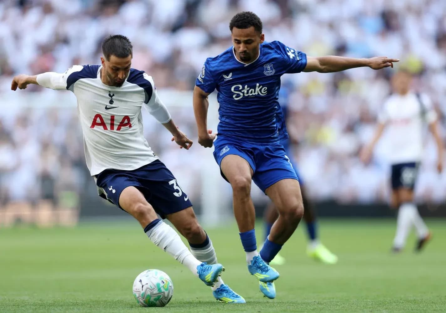Jugador de Tottenham compitiendo por el balón Jugador de Tottenham compitiendo por el balón