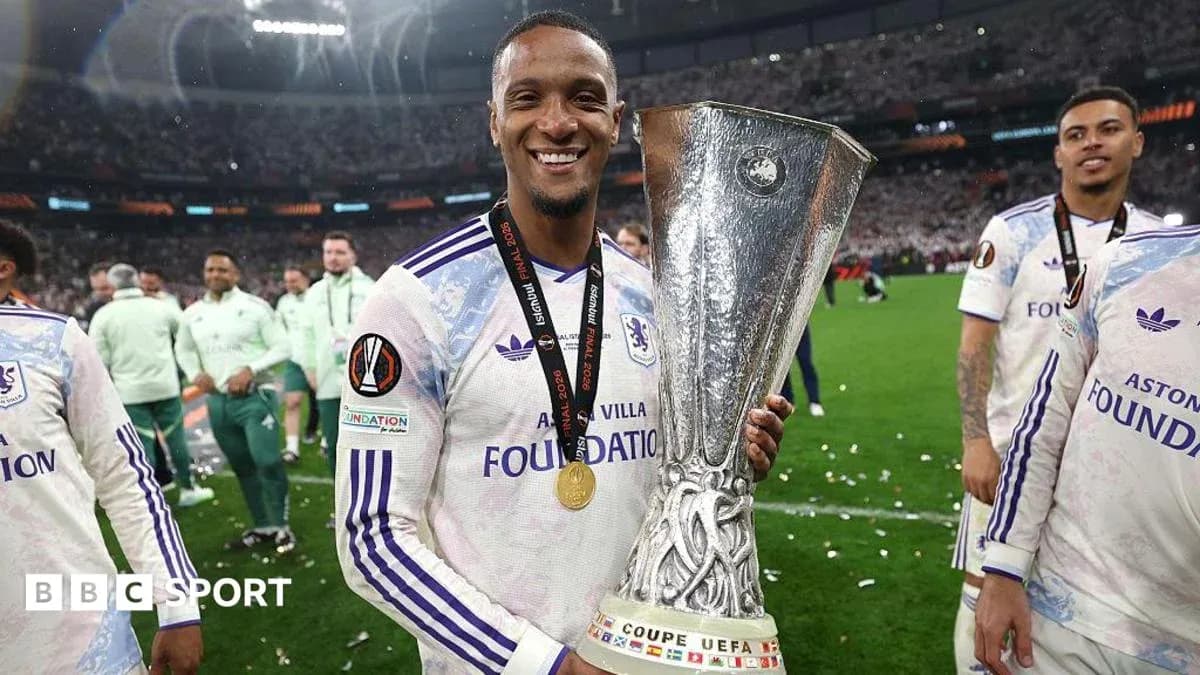 Jugador sosteniendo trofeo de la UEFA tras victoria Jugador sosteniendo trofeo de la UEFA tras victoria