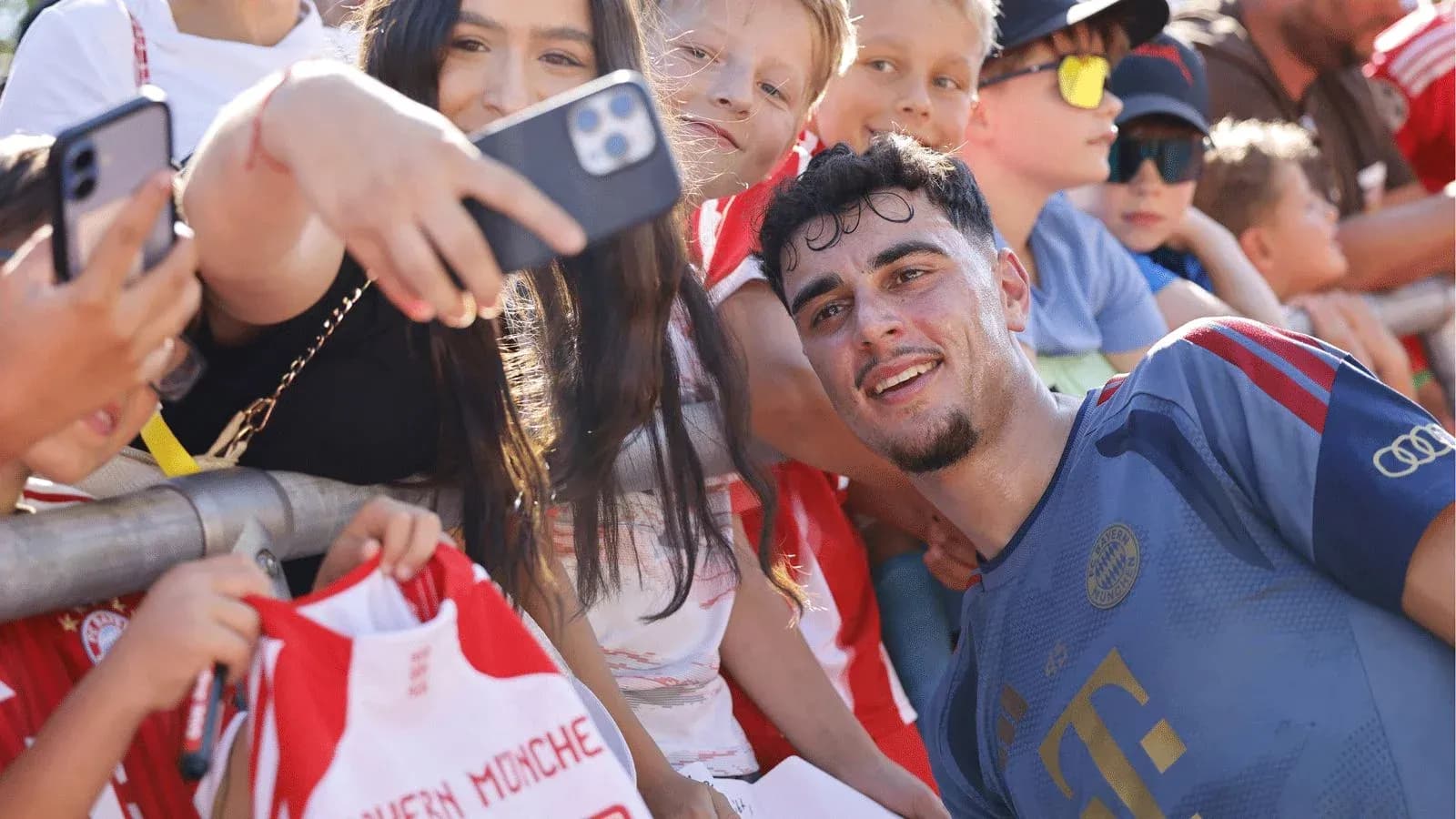 Jugador sonriendo mientras posa con fans Jugador sonriendo mientras posa con fans