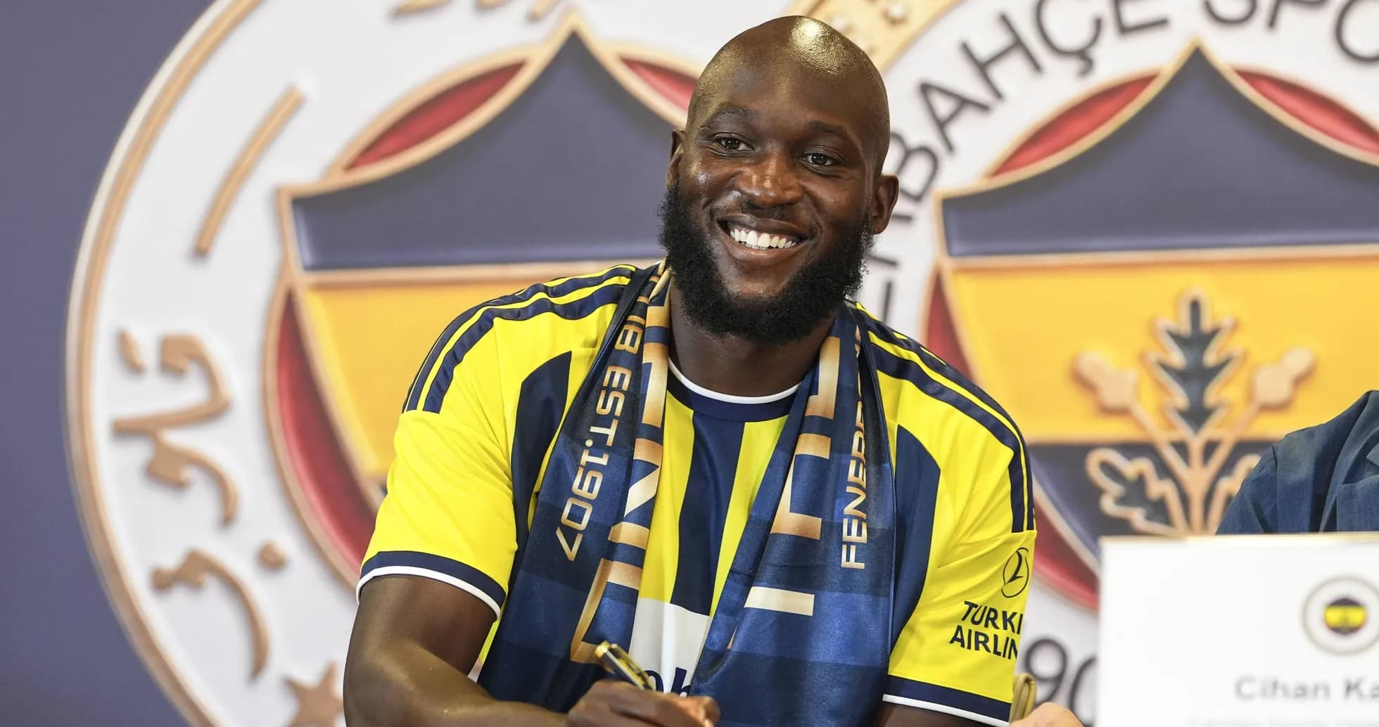 Jugador sonriendo durante la firma de contrato Jugador sonriendo durante la firma de contrato