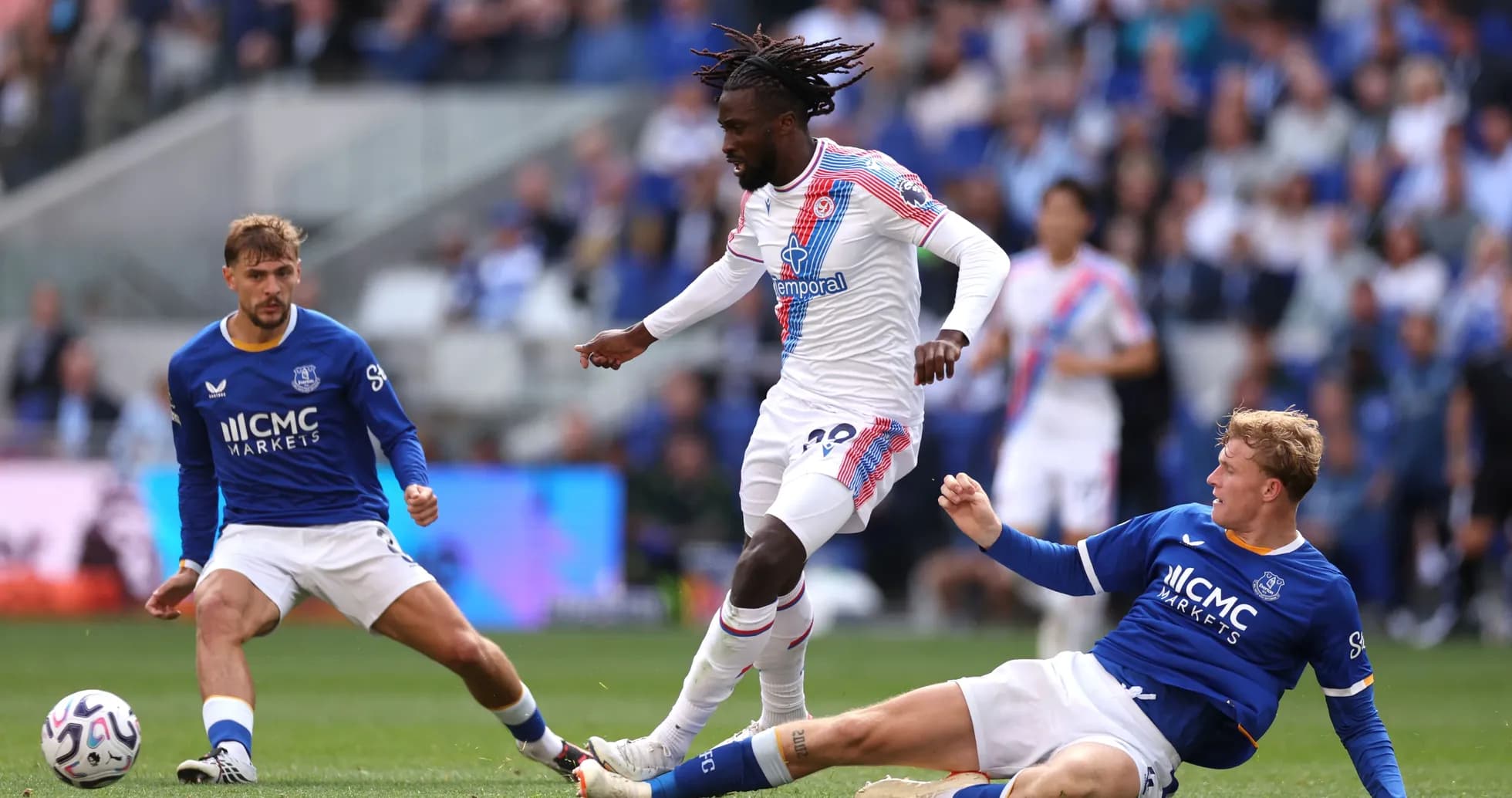 Jugador de Crystal Palace driblando entre dos defensores de Everton Jugador de Crystal Palace driblando entre dos defensores de Everton