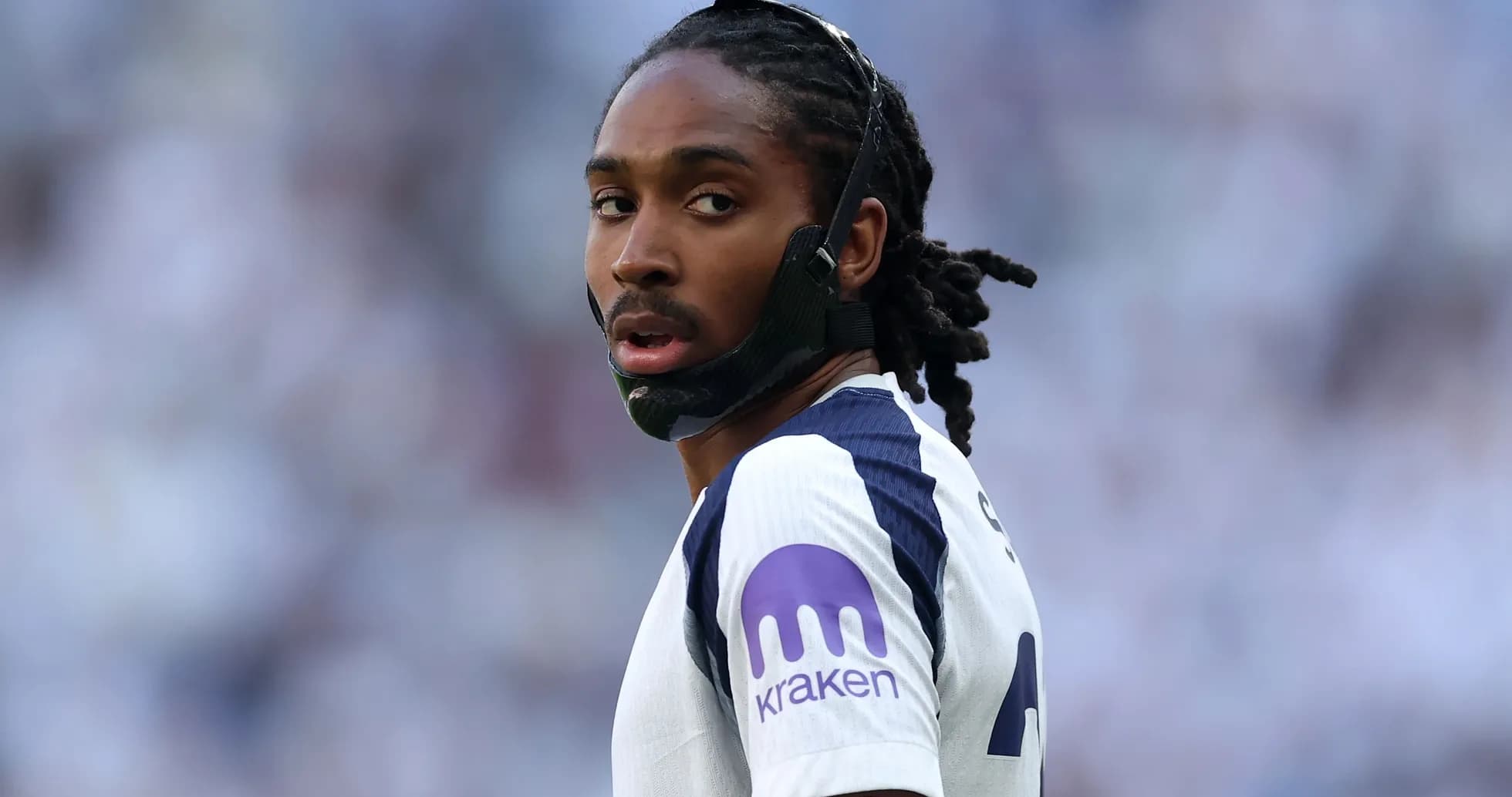 Jugador con máscara en el campo durante partido Jugador con máscara en el campo durante partido