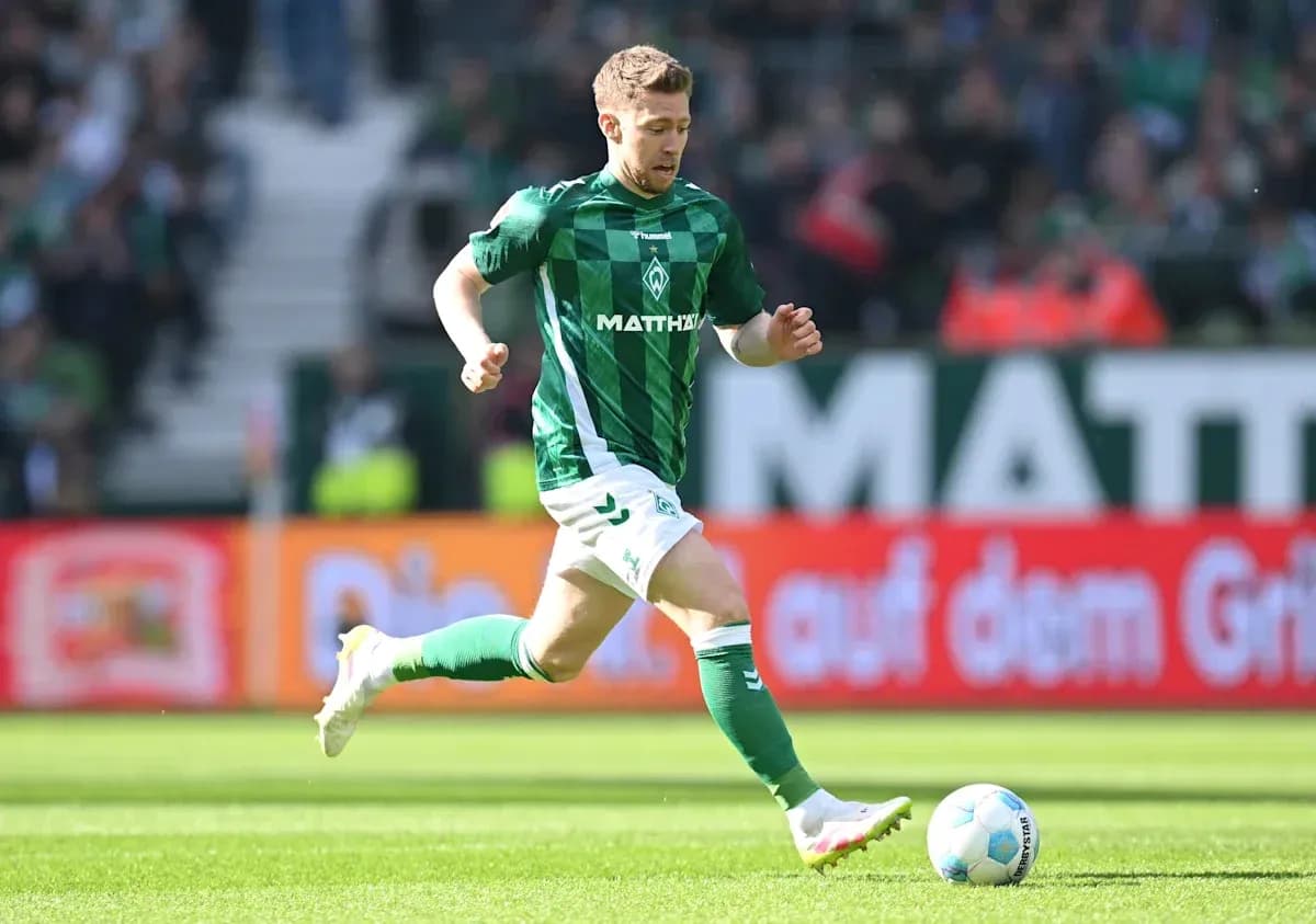 Jugador de Werder Bremen corriendo tras el balón Jugador de Werder Bremen corriendo tras el balón
