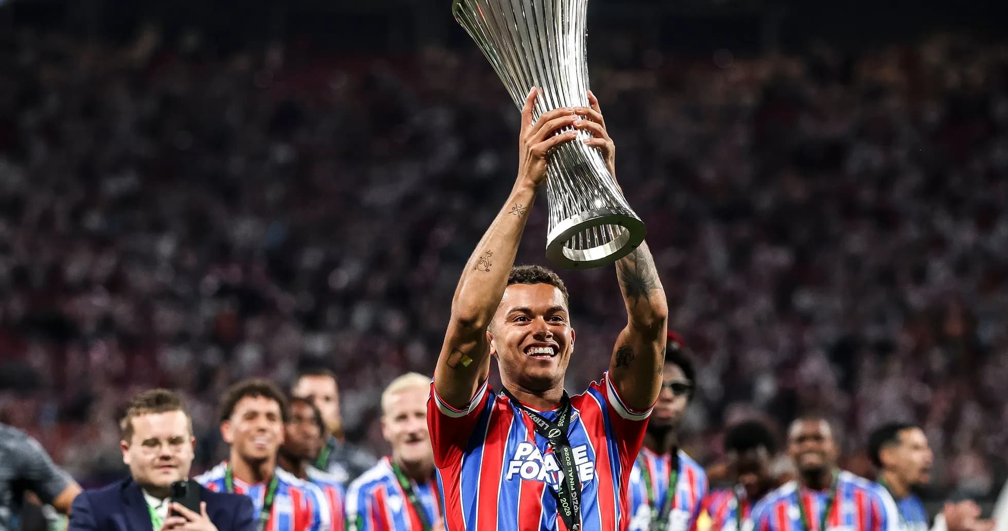 Jugador levantando trofeo de la UEFA en celebración Jugador levantando trofeo de la UEFA en celebración
