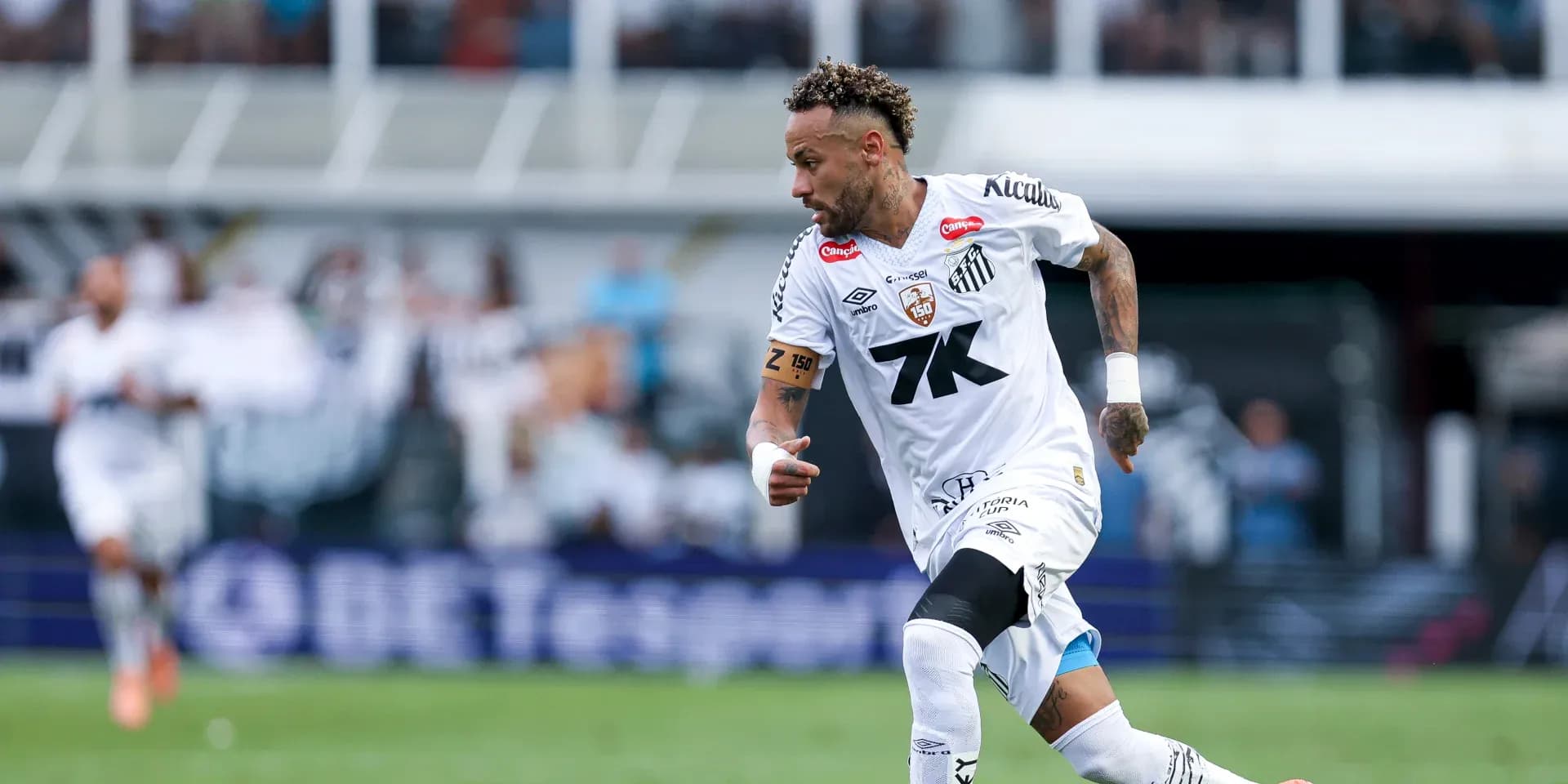 Jugador de Santos corriendo con el balón en el campo Jugador de Santos corriendo con el balón en el campo