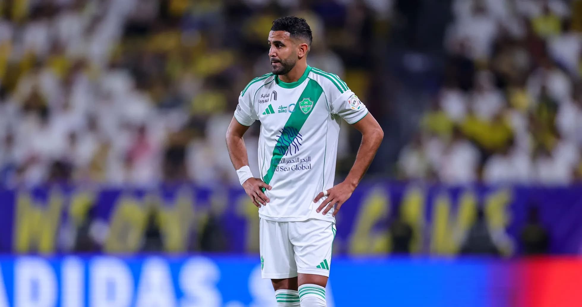 Jugador de fútbol con camiseta blanca y verde en el campo Jugador de fútbol con camiseta blanca y verde en el campo
