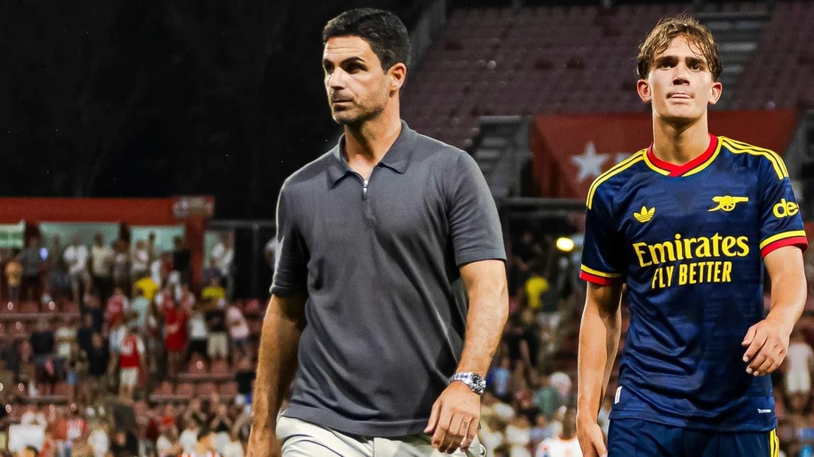 Entrenador y jugador de Arsenal caminando por el campo Entrenador y jugador de Arsenal caminando por el campo